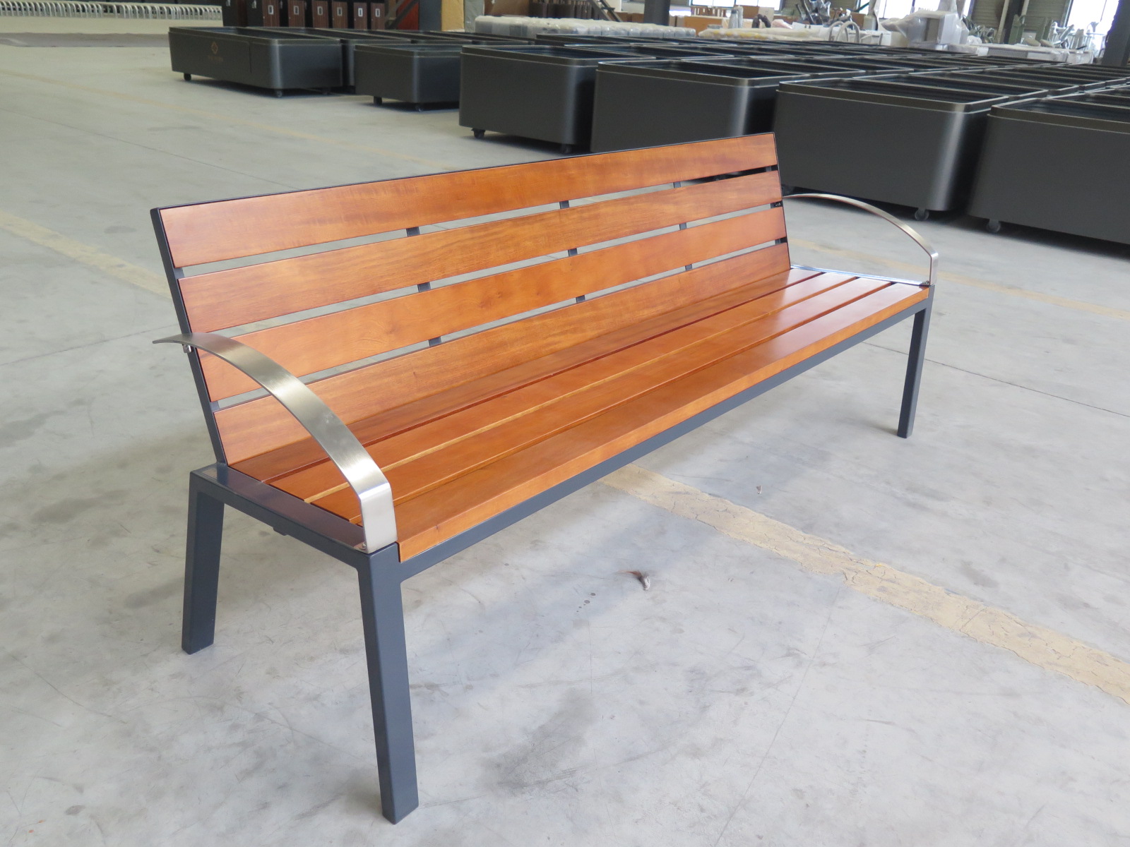 Outdoor bench with wooden slats and black powder-coated steel frame for parks and gardens